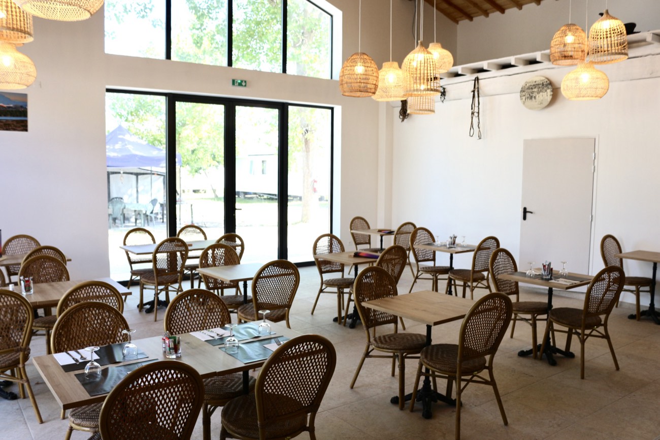 Salle de restaurant lumineuse avec grandes baies vitrées