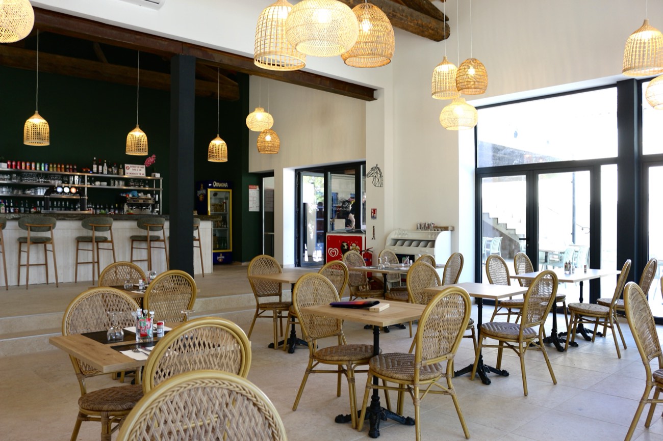 Salle du restaurant La Palaïgue avec bar et suspensions en rotin